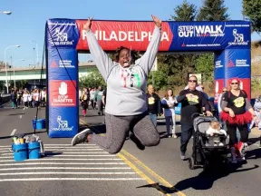Person jumps in front of the Step Out Walk for Diabetes banner.