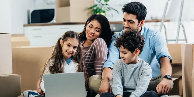 Smiling young Latino family looking at laptop computer