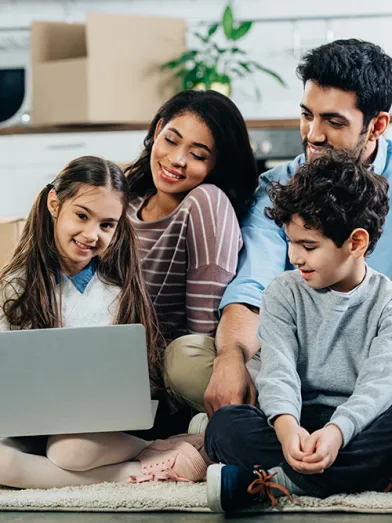 Smiling young Latino family looking at laptop computer