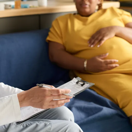 Nurse writing a prescription for pregnant woman