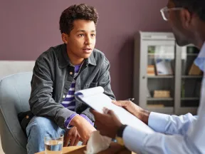 Teenage boy talking to doctor in office