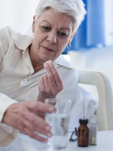 Senior woman in bed taking medication